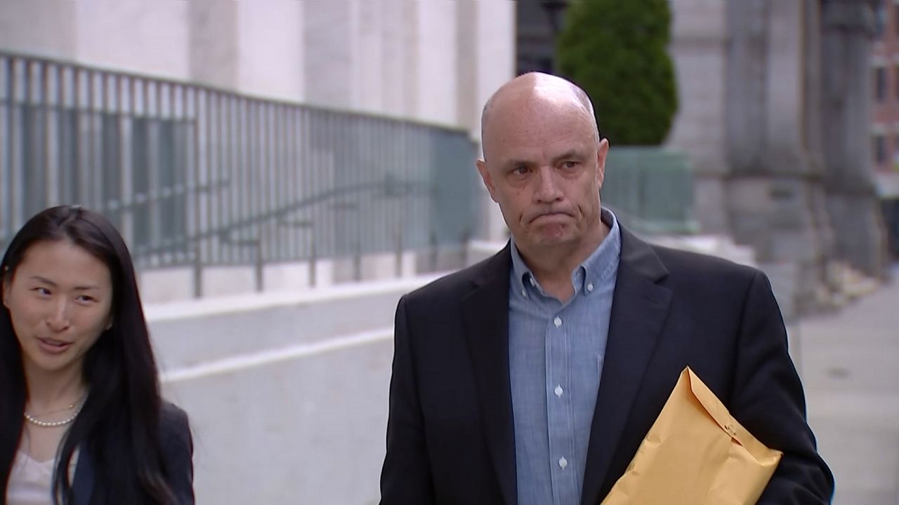 rich crist walks past courthouse holding envelope