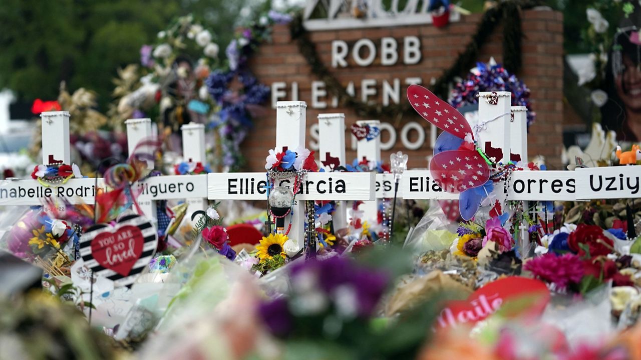 Crosses are surrounded by flowers and other items at a memorial, June 9, 2022, for the victims of a shooting at Robb Elementary School in Uvalde, Texas. (AP Photo/Eric Gay, File)