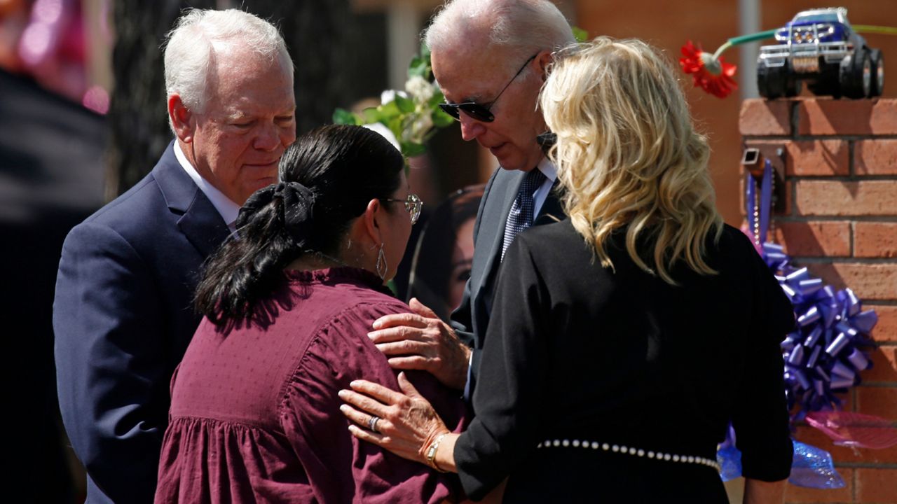 President Joe Biden and first lady Jill Biden comfort principal Mandy Gutierrez as superintendent Hal Harrell stands next to them, at the memorial outside Robb Elementary School to honor the victims killed in this week's school shooting in Uvalde, Texas, on May 29, 2022.