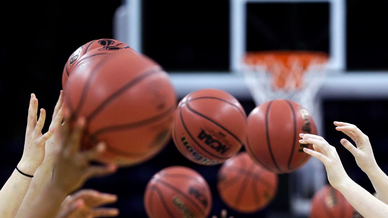 Athletes toss basketballs in a drill at practice. (AP Photo/Elaine Thompson)