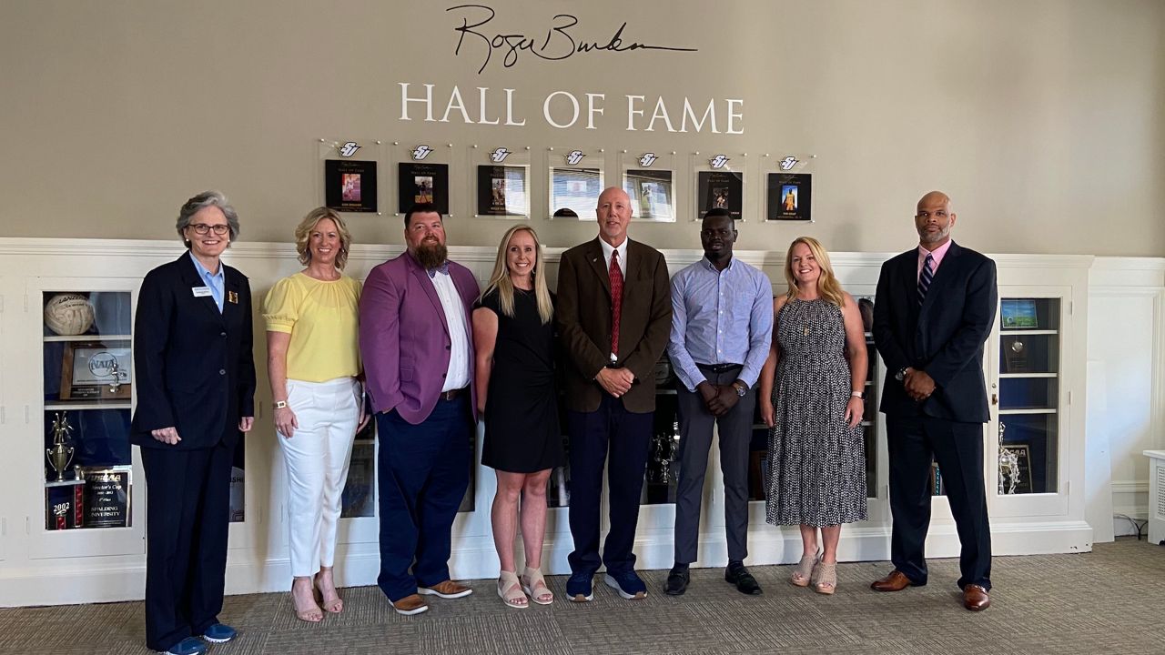 Roger Burkman, center, and the inaugural class of the Roger Burkman Hall of Fame at Spalding University. (Spectrum News 1/Adam K. Raymond)