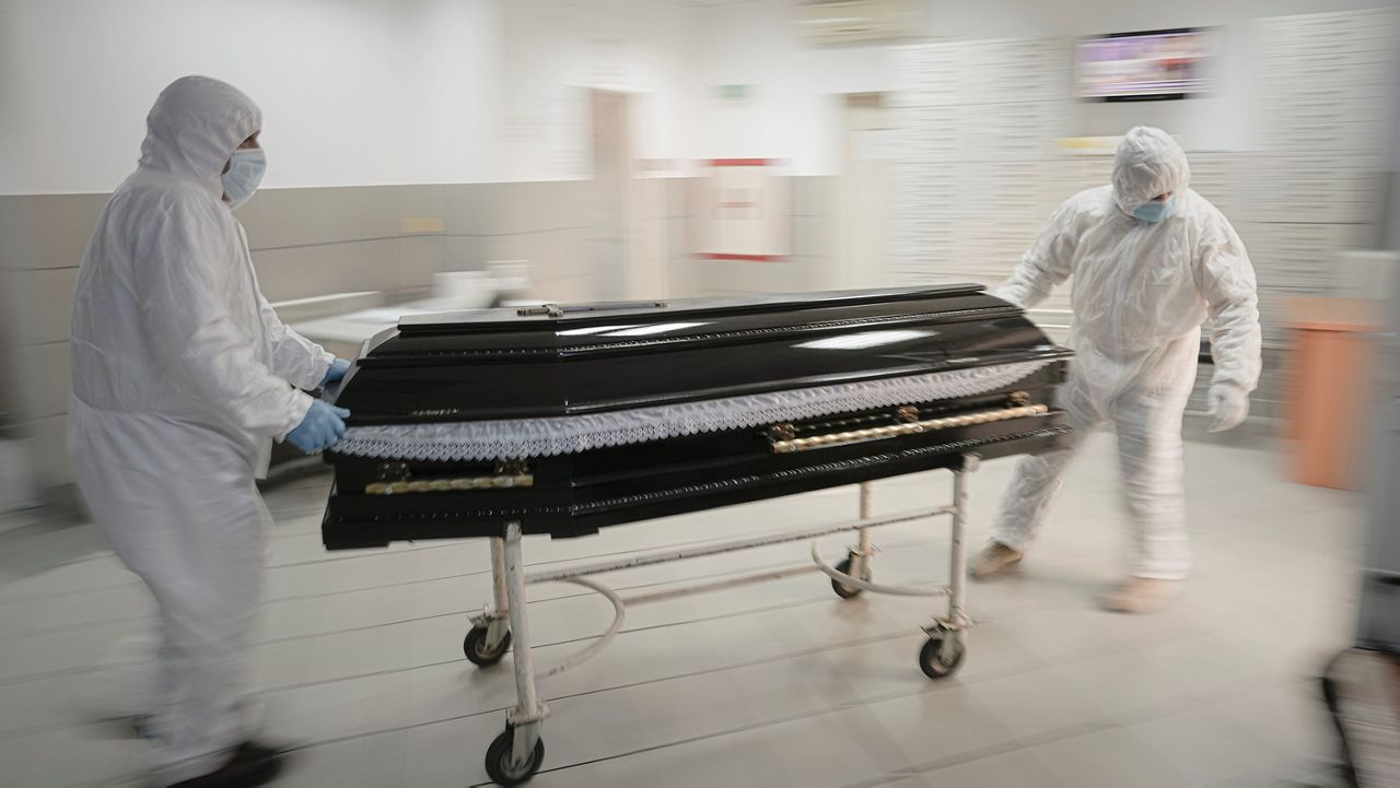 Funeral house employees drag a coffin on a trolley as they arrive at the University Emergency Hospital morgue to take a COVID-19 victim for burial, in Bucharest, Romania, Nov. 8, 2021.  (AP Photo/Vadim Ghirda)