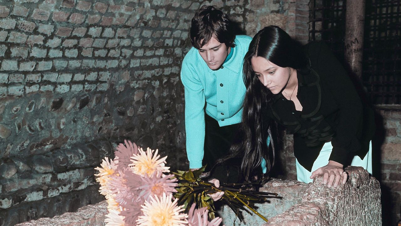 Olivia Hussey and Leonard Whiting, who are playing the title roles in Franco Zeffirelli's "Romeo and Juliet," place flowers on the "Tomba di Giulietta", or the Tomb of Juliet, in Verona, northern Italy, on Oct. 22, 1968. (AP Photo/File)