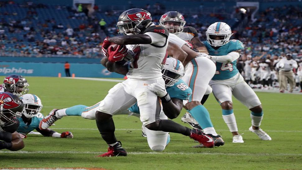 Tampa Bay Buccaneers running back Ronald Jones II (27) avoids a tackle by Miami Dolphins defensive tackle Vincent Taylor (96), to score a touchdown during the first half of an NFL preseason football game Thursday, Aug. 9, 2018, in Miami Gardens, Fla. (AP Photo/Lynne Sladky)