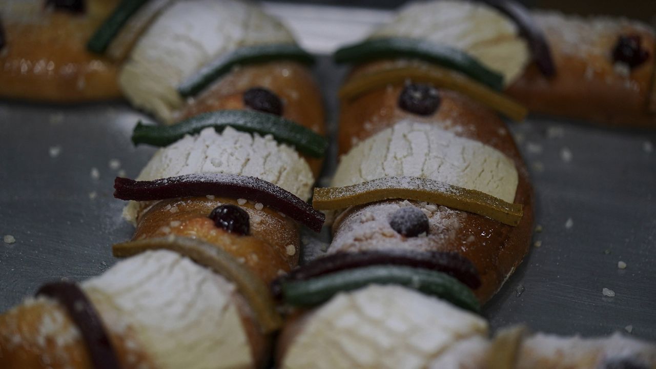 Sugar is sprinkled on traditional "Rosca de Reyes" pastries at Chef Francisco Vasquez's bakery the day before Epiphany, or Three Kings Day, in Mexico City, Wednesday, Jan. 5, 2022. (AP Photo/Fernando Llano)