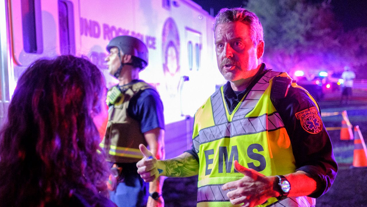 Captain Matt Clark, right, and Chief Deputy Medical Director Dr. Heidi Abraham, left, of Austin County EMS, discuss next steps after a fatal shooting during a Juneteenth celebration at Old Settlers Park in Round Rock, Texas, late Saturday, June 15, 2024. (Cross Harris/Austin American-Statesman via AP)