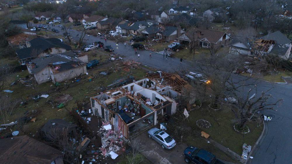 Debris litters the ground surrounding homes, damaged by a tornado, on Oxford Drive and Stratford Drive in Round Rock, Texas Monday, March 21, 2022. (Jay Janner/Austin American-Statesman via AP)