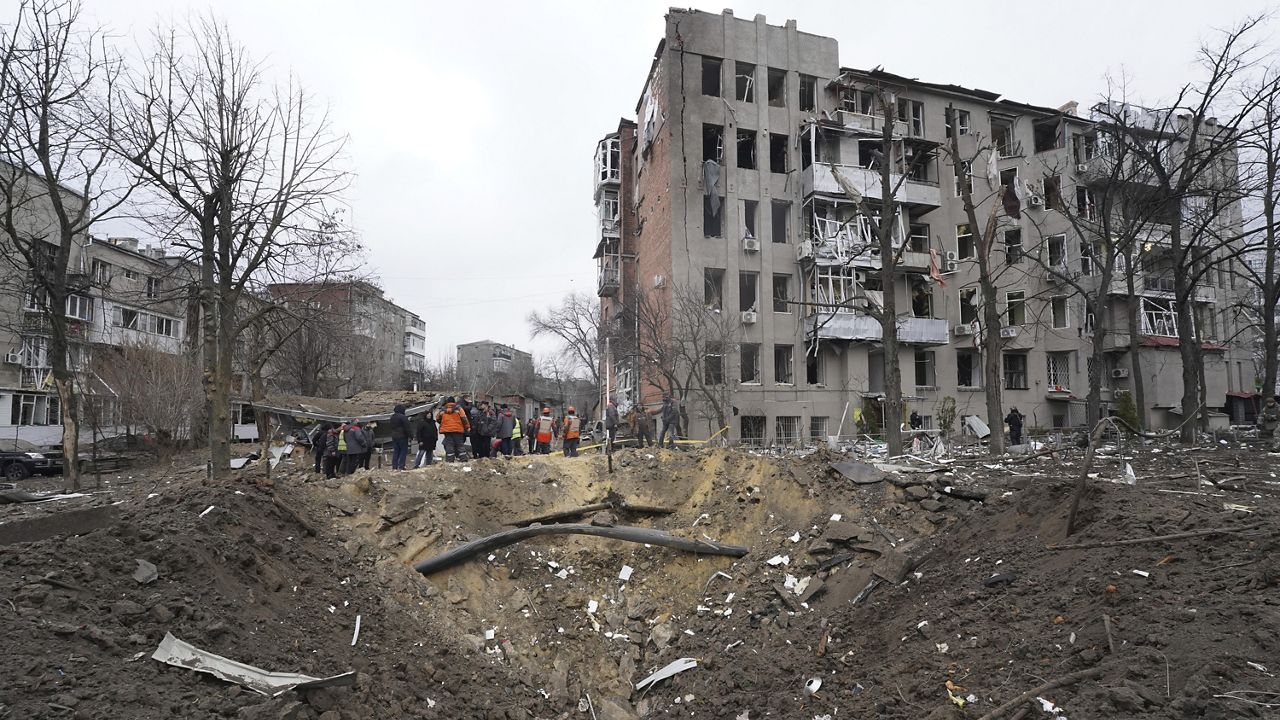 Municipal workers clear the rubble in front of a residential building damaged by a Russian missile strike in Kharkiv, Ukraine, Tuesday, Jan. 2, 2024. (AP Photo/Andrii Marienko)