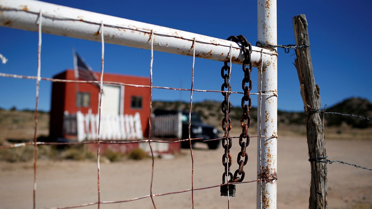 A rusted chain hangs on the fence at the entrance to the Bonanza Creek Ranch film set in Santa Fe, N.M., Wednesday, Oct. 27, 2021. (AP Photo/Andres Leighton)
