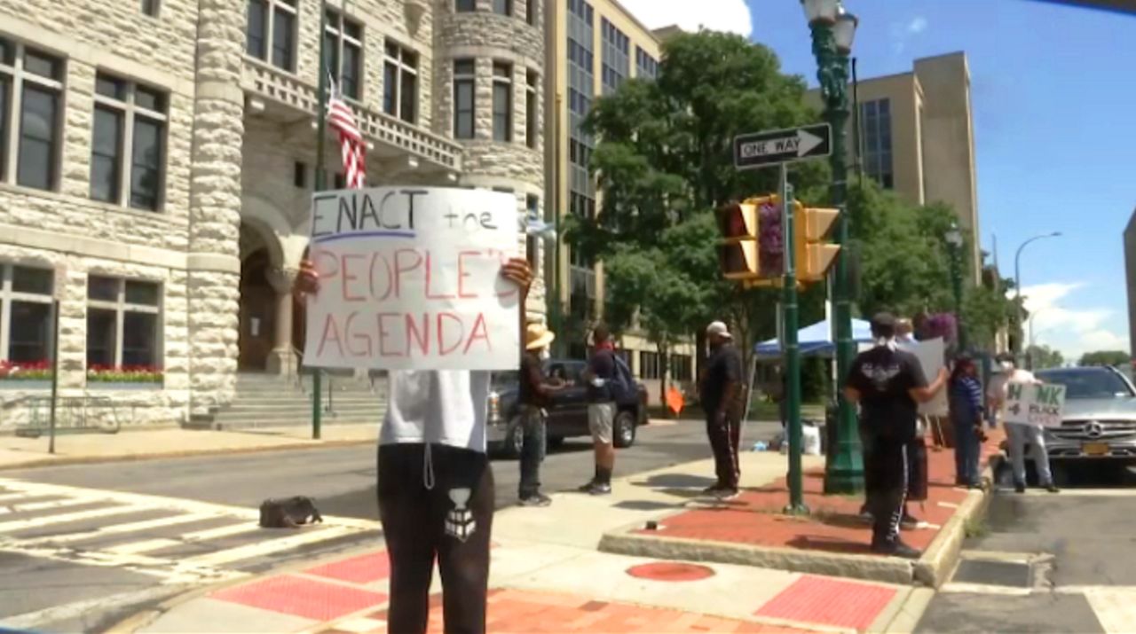 Man holds up a sign in Syracuse