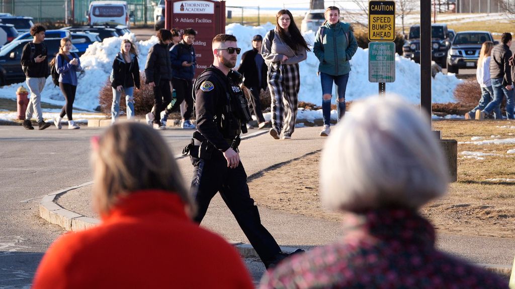 Parents wait as students are released from school, under watch by local police, outside Thornton Academy following police activity in the area, Friday, Feb. 9, 2024, in Saco, Maine. Police in a Saco asked residents to shelter in place Friday afternoon while they searched for suspects after an exchange of gunfire and vehicle crash at a busy intersection spurred a brief citywide school lockdown. (AP Photo/Charles Krupa)