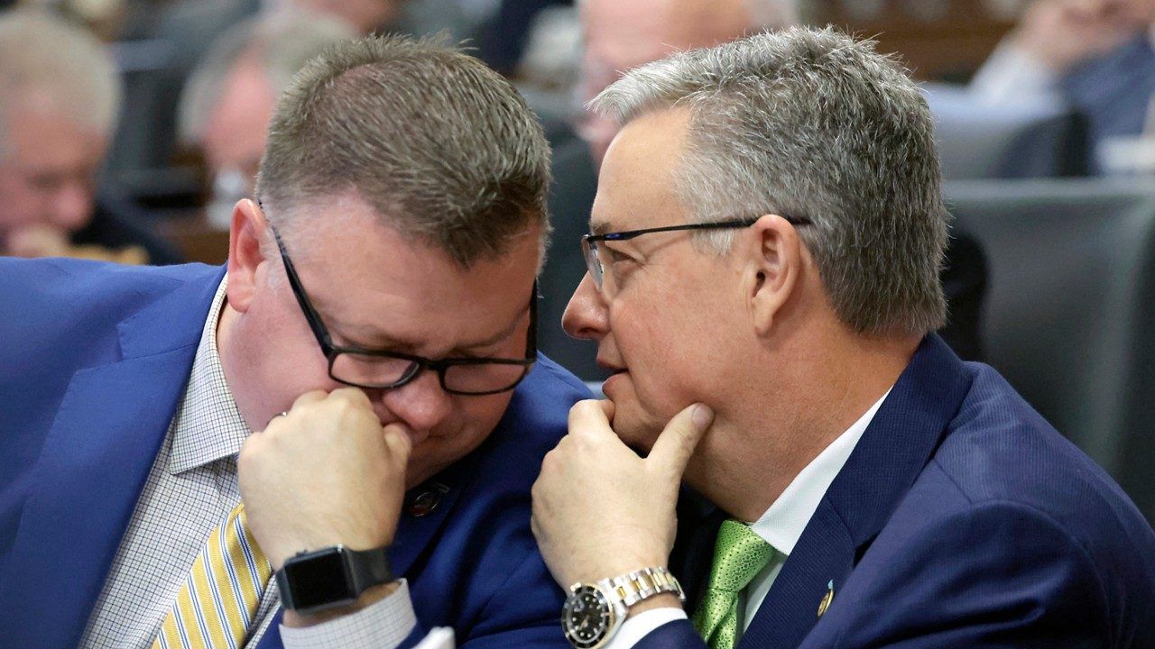 Rep. Jason Saine, R-Lincoln, left, and Sen. Jim Perry, R-Lenoir, confer on the House floor as lawmakers debate redistricting bills at the Legislative Building on Tuesday, Oct. 24, 2023, in Raleigh, N.C. (AP Photo/Chris Seward)