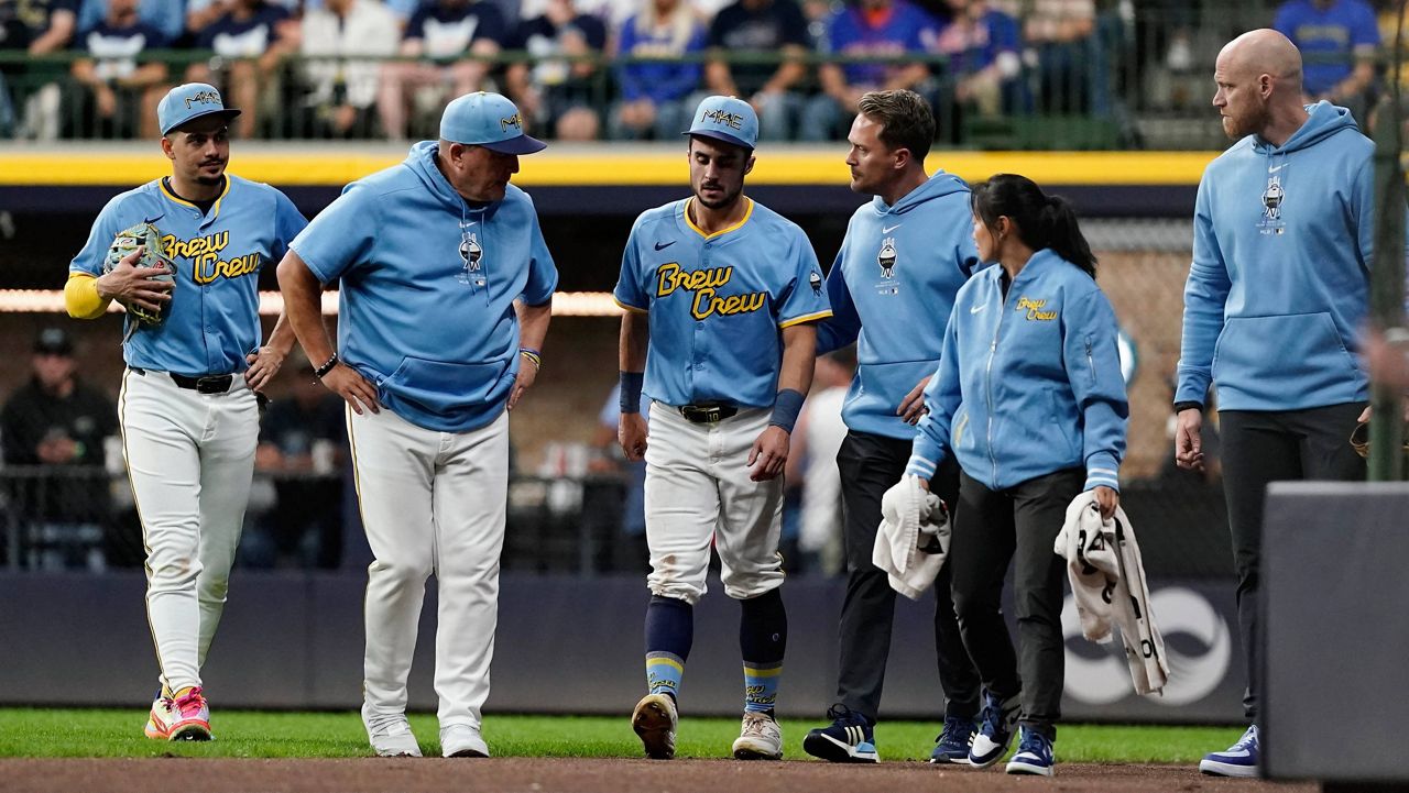 Milwaukee Brewers' Sal Frelick, center, walks off the field during the third inning of a baseball game against the New York 