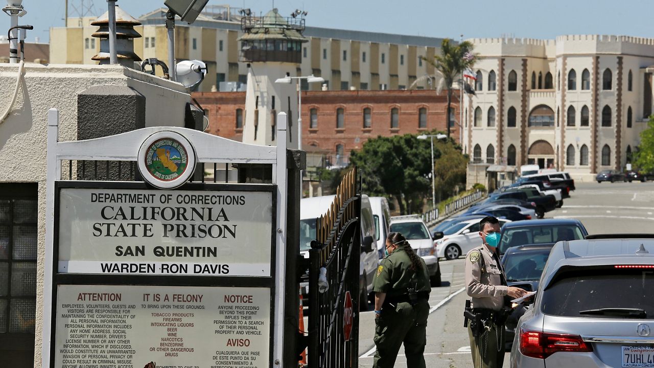 A guard checks vehicles entering the main gate at San Quentin State Prison on April 12, 2022, in San Quentin, Calif. (AP Photo/Eric Risberg)