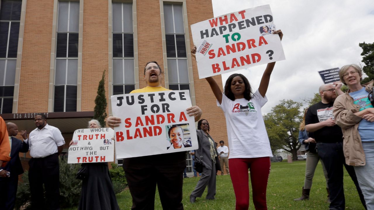 Demonstrators protest outside the courthouse after former Texas state trooper Brian Encinia's arraignment hearing Tuesday, March 22, 2016, in Hempstead, Texas. Encinia, who arrested Sandra Bland, was arraigned on a misdemeanor perjury charge. (AP Photo/David J. Phillip)