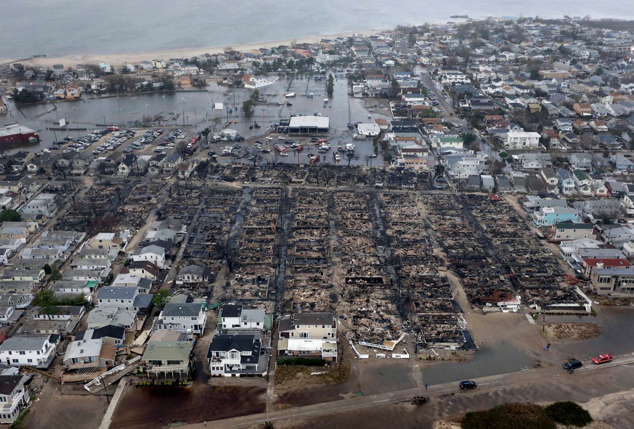 This Oct. 30, 2012 file aerial photo shows burned-out homes in the Breezy Point section of the Queens borough New York after a fire. It burned down as it was inundated by floodwaters, transforming a quaint corner of the Rockaways into a smoke-filled debris field. (AP Photo/Mike Groll)