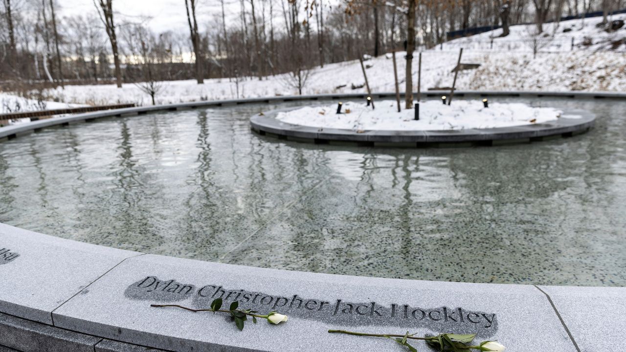 Flowers rest on the Sandy Hook Permanent Memorial, Monday, Dec. 12, 2022, in Newtown, Conn. The names of the 20 first graders and six educators killed a short distance away at Sandy Hook Elementary School 10 years ago are engraved in concrete around a memorial pool with a sycamore tree in the middle. (AP Photo/Julia Nikhinson).