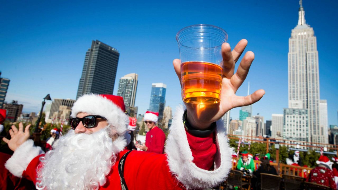 A man dressed as Santa Claus holds a beer as he and others participate in SantaCon on on Saturday, Dec. 13, 2014 in New York.