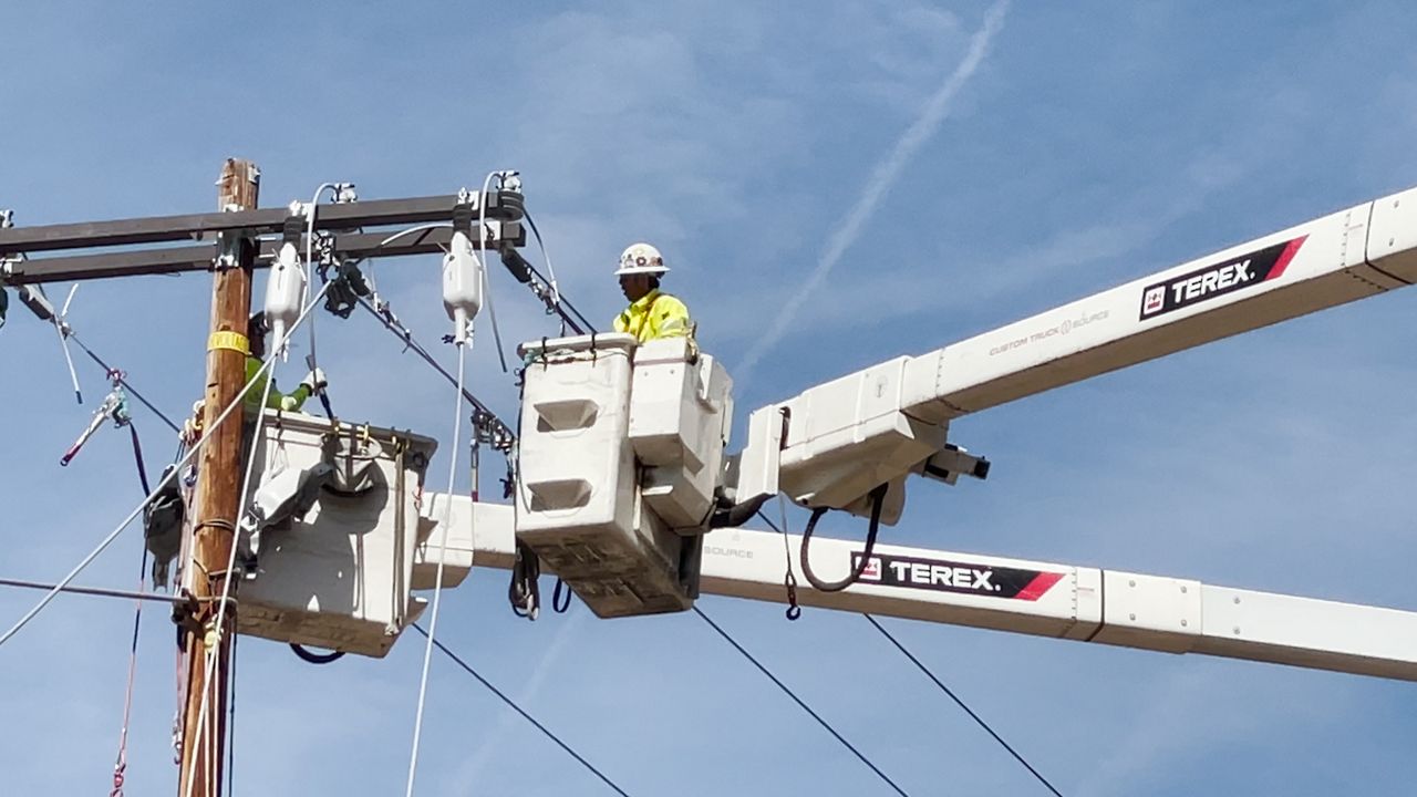 Workers in a crane installing wires