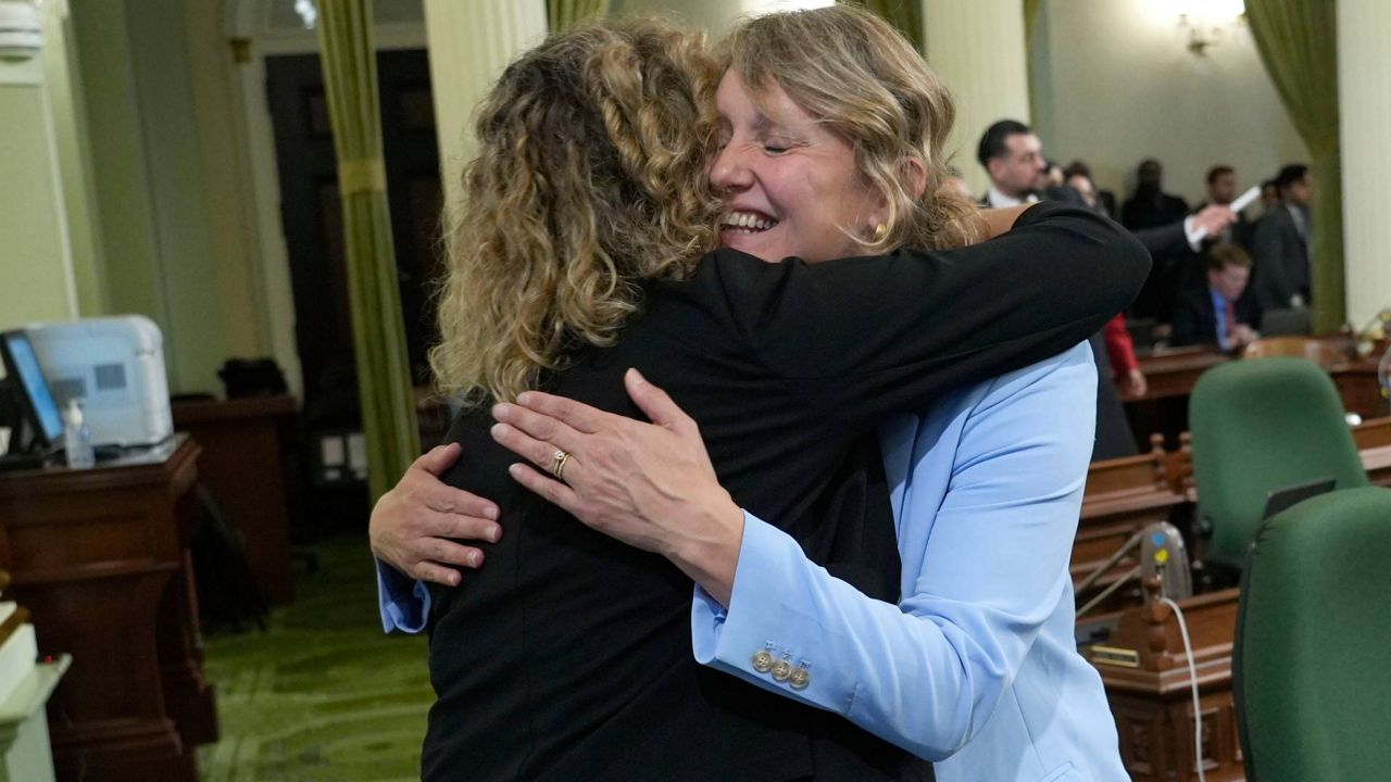 Assemblywoman Pilar Schiavo, D-San Fernando Valley, left, congratulates Assemblywoman Buffy Wicks, D-Oakland, after Wicks' measure that would force Big Tech companies to pay media outlets for using their news content, was approved by the Assembly at the Capitol in Sacramento, Calif., on Thursday. (AP Photo/Rich Pedroncelli)