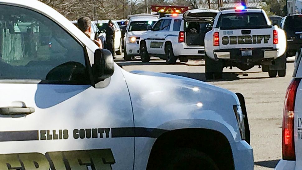 Law enforcement personnel from the Ellis County Sheriff's Office park outside a high school in Italy, Texas, following an active shooter incident at the school Monday morning, Jan. 22, 2018. Sheriff's officials said a boy who is a student at the school was taken into custody. (Jennifer Lindgren/KTVT Dallas Fort Worth via AP)