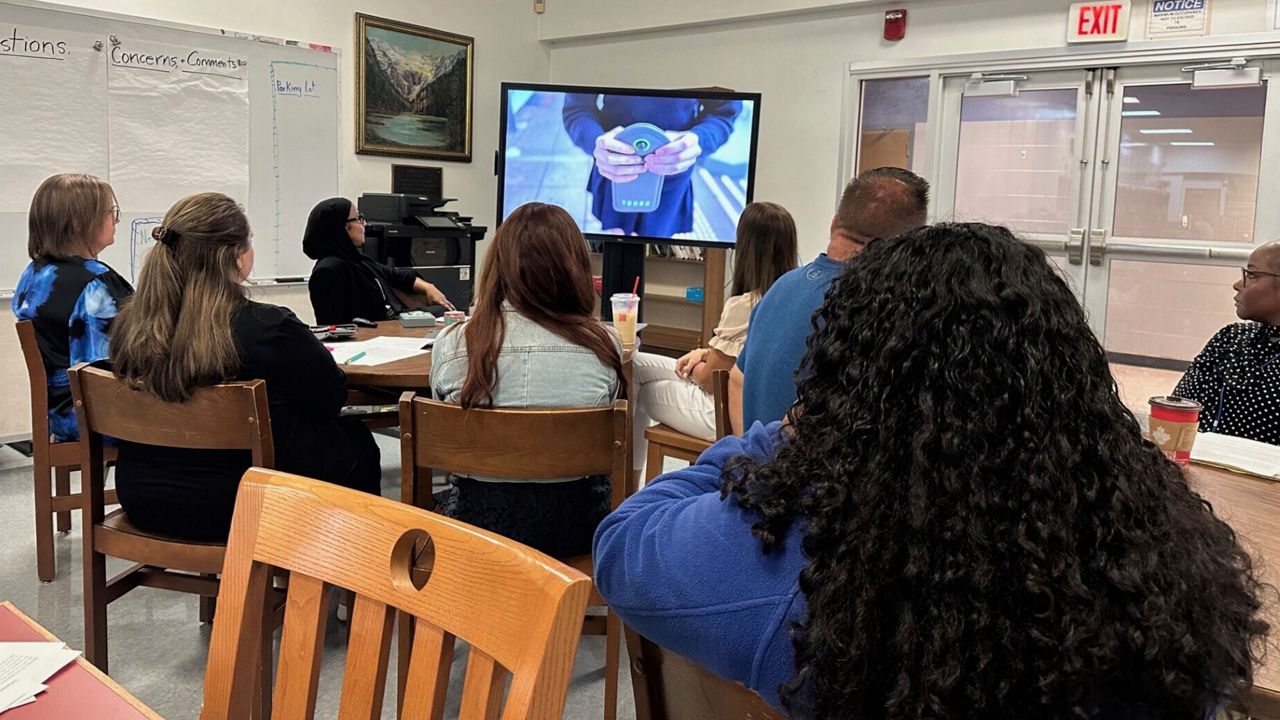 Parents and students in the Lackawanna City School District watch a video demonstrating a new policy that will require the students to lock their cellphones in pouches during the school day, Aug. 19, 2024, in Lackawanna, N.Y. 