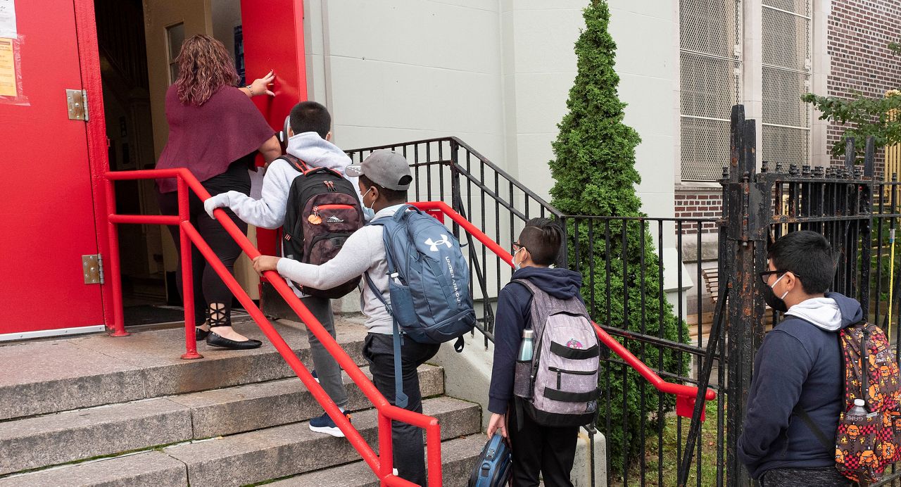 Students enter a school building in New York. (AP Photo)