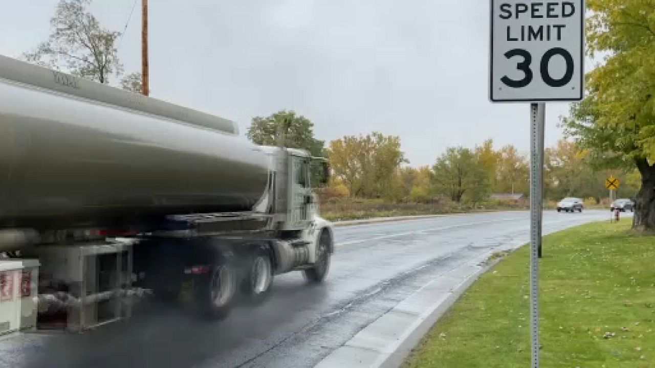 Speed limit sign and passing vehicles.