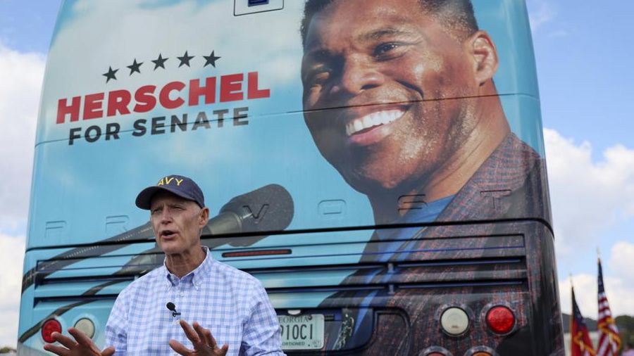 Florida Sen. Rick Scott supports Republican senate hopeful Herschel Walker at Walker's "United Georgia" campaign bus tour (Arvin Temkar/Atlanta Journal-Constitution via AP)