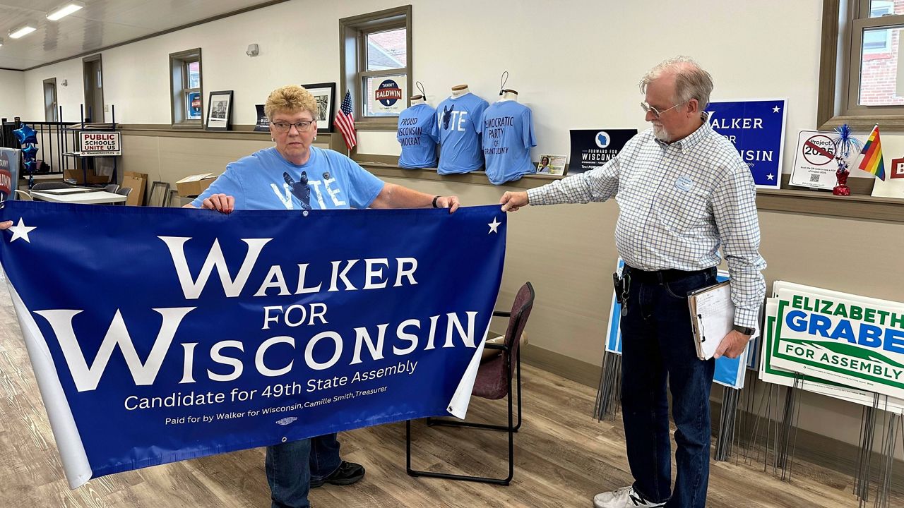 Grant County Democratic Party Chair Joyce Bos, left, and Democratic legislative candidate Scott Abbot Walker inspect a campaign banner 