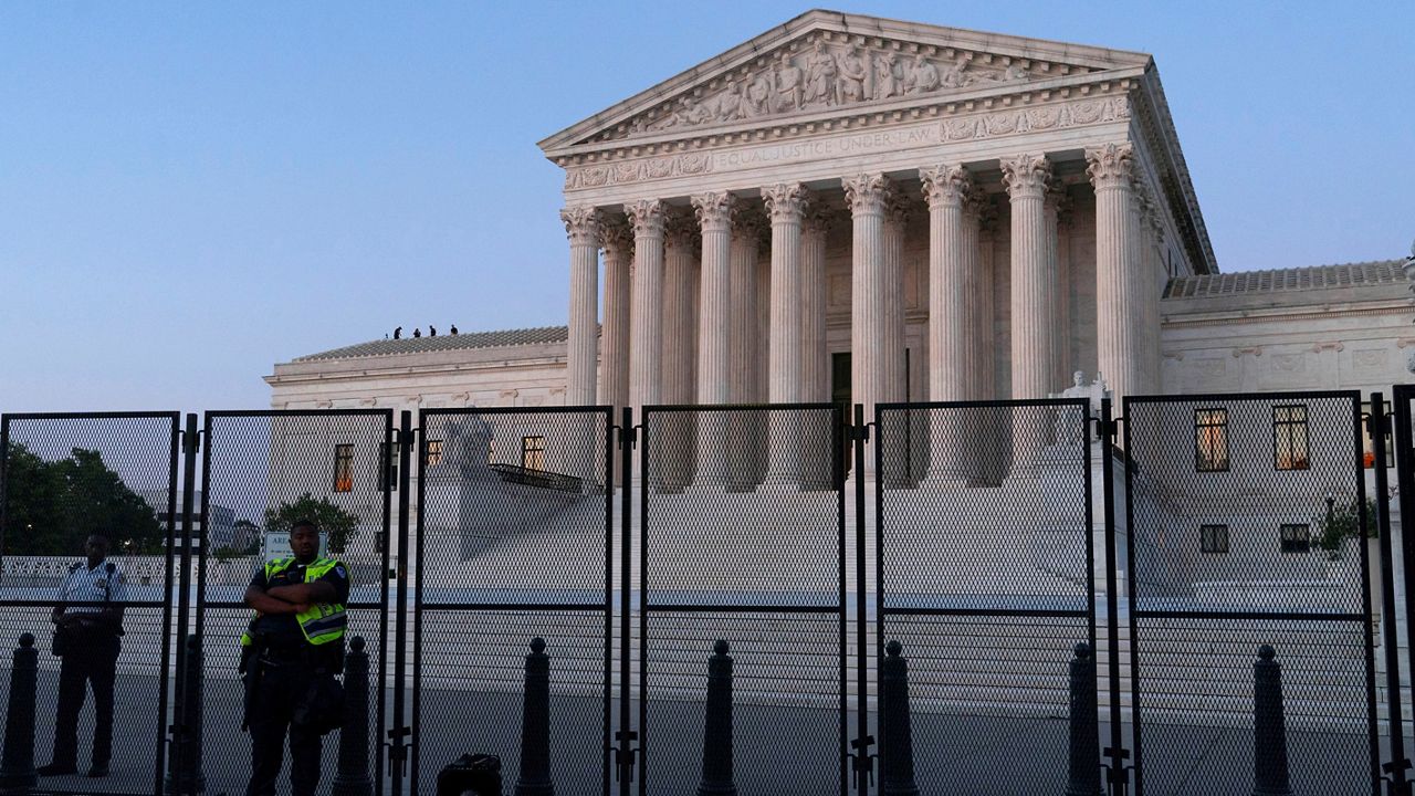 The Supreme Court is guarded at dusk, following the court's decision to overturn Roe v. Wade in Washington, Friday, June 24, 2022. (AP Photo/Jacquelyn Martin)