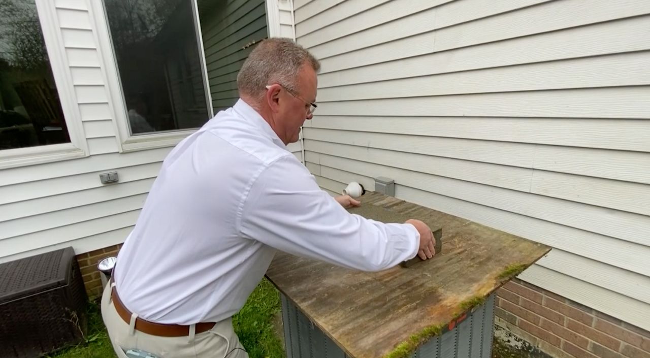 John Sizemore installs a simple cover over an AC for the winter.