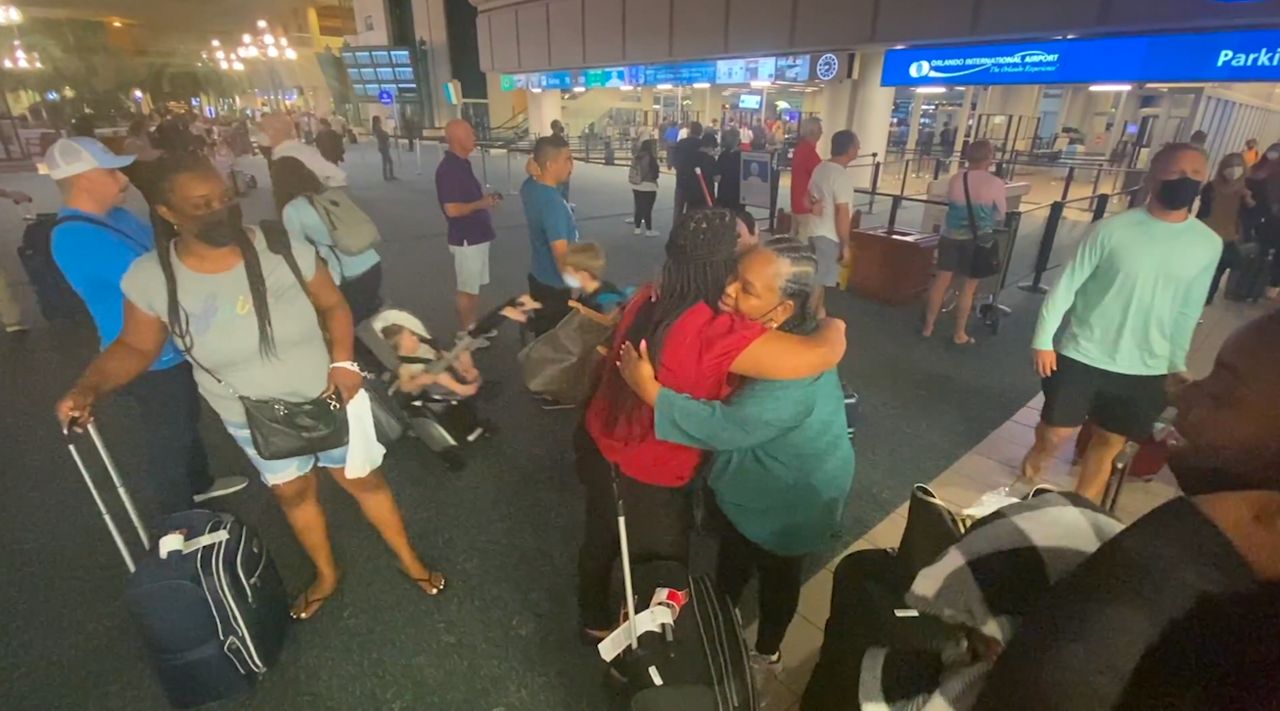 Quincy Green embraces family members after returning safely to Orlando from a stuck cruise ship in the Dominican Republic. (Spectrum News 13)