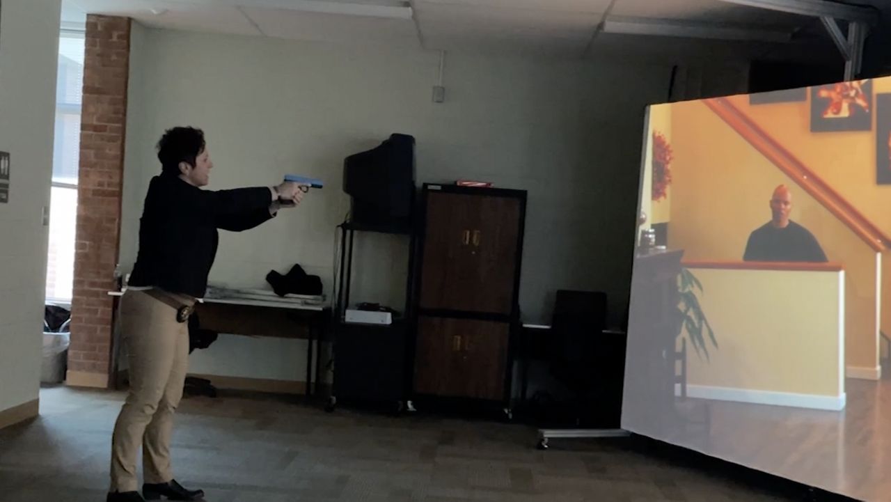 Officer points gun at screen.