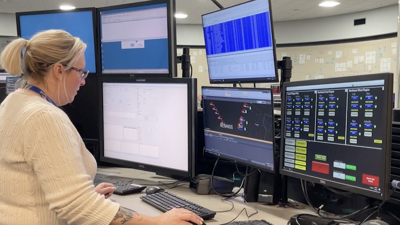 woman facing numerous computer screens
