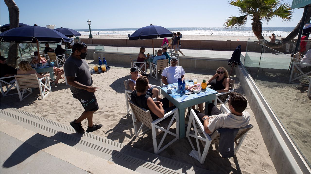 People sit at tables at the Beach House Grill Thursday, May 21, 2020, in San Diego. (AP Photo/Gregory Bull)