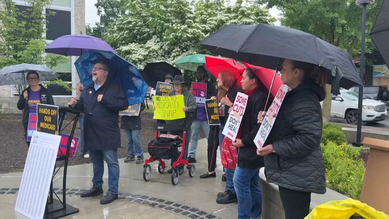 people at a hands-off-medicaid protest in the rain