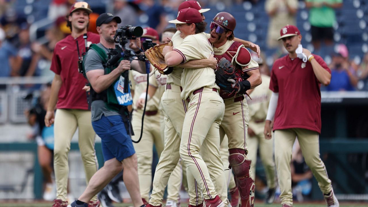 Florida State pitcher Connor Hults (15) is mobbed by teammates after defeating North Carolina by a score of 9-5 in an elimination game during the NCAA College World Series baseball game on Tuesday, June 18, 2024, in Omaha, Neb. (AP Photo/Mike Buscher)