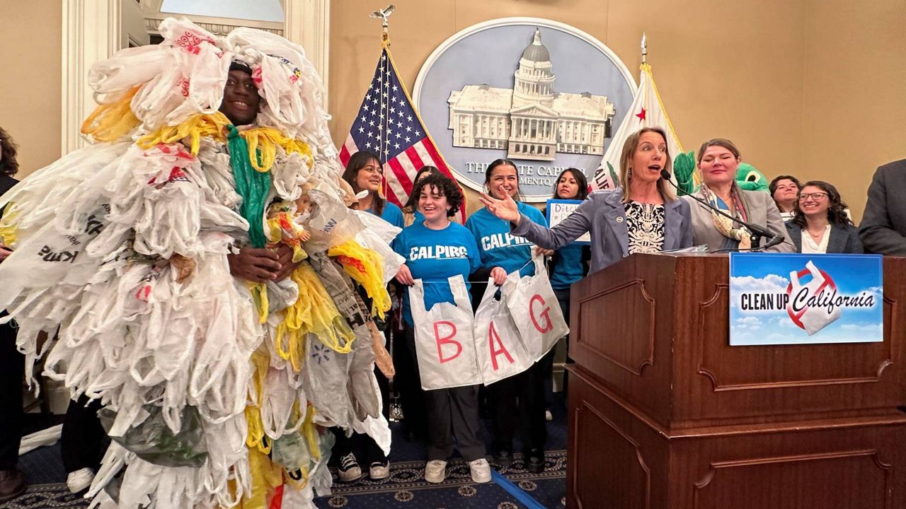 California Democratic state Sen. Catherine Blakespear gestures toward a person covered in plastic bags during a news conference at the Capitol in Sacramento, Calif., on Thursday. (AP/Adam Beam)