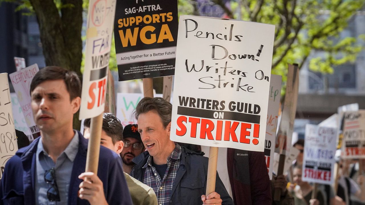 Late night talk show host Seth Meyers, right, joins striking members of the Writers Guild of America on the picket line during a rally outside Silvercup Studios, Tuesday May 9, 2023, in New York. (AP Photo/Bebeto Matthews)