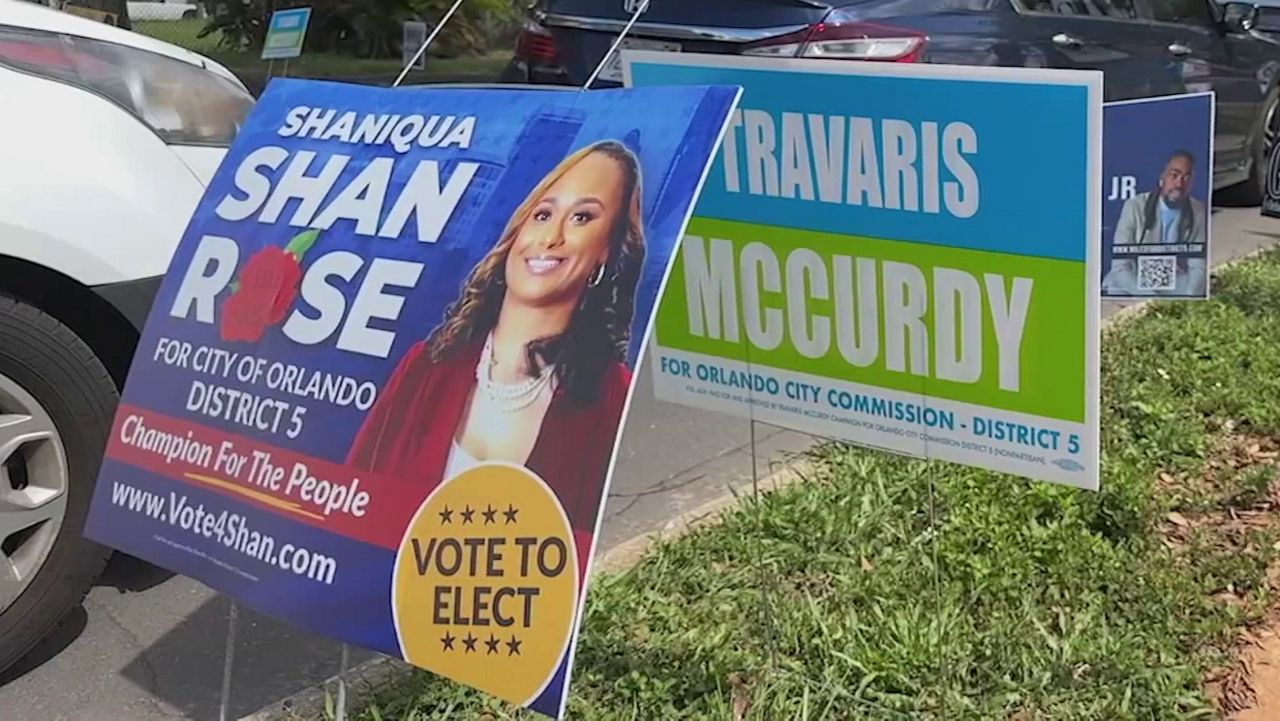 Signs for Orlando District 5 commissioner candidates Saniqua Rose and Travaris McCurdy are posted outside a polling location. (Spectrum News/Jeff Allen)