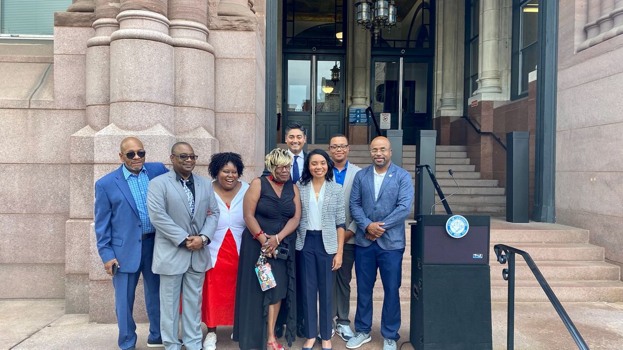 Sheryl Long stands with family and Mayor Aftab Pureval outside City Hall after the mayor announced he'd selected her to be Cincinnati's next city manager. (Casey Weldon/Spectrum News 1)