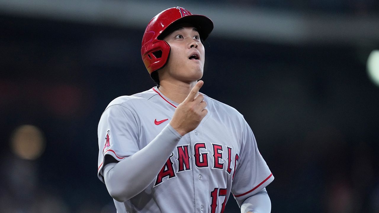 Los Angeles Angels designated hitter Shohei Ohtani motions in a joking manner after drawing a walk during the seventh inning of a baseball game against the Houston Astros, Sunday, Sept. 11, 2022, in Houston. (AP Photo/Kevin M. Cox)