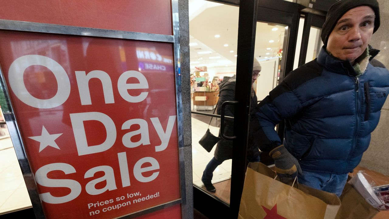 A shopper leaves Macy's on Saturday, Dec. 10, 2022 in Boston.
