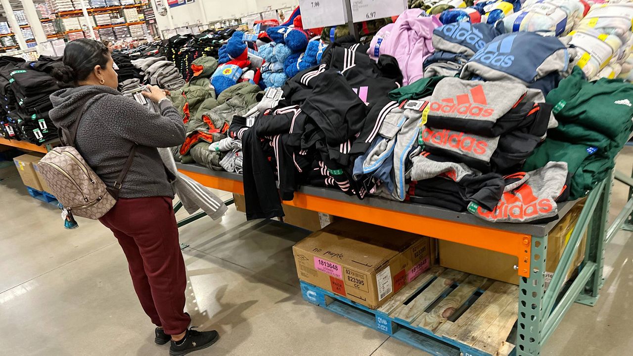 A shopper looks over clothing on display in a Costco warehouse Wednesday, Dec. 4, 2024, in Sheridan, Colo. (AP Photo/David Zalubowski)