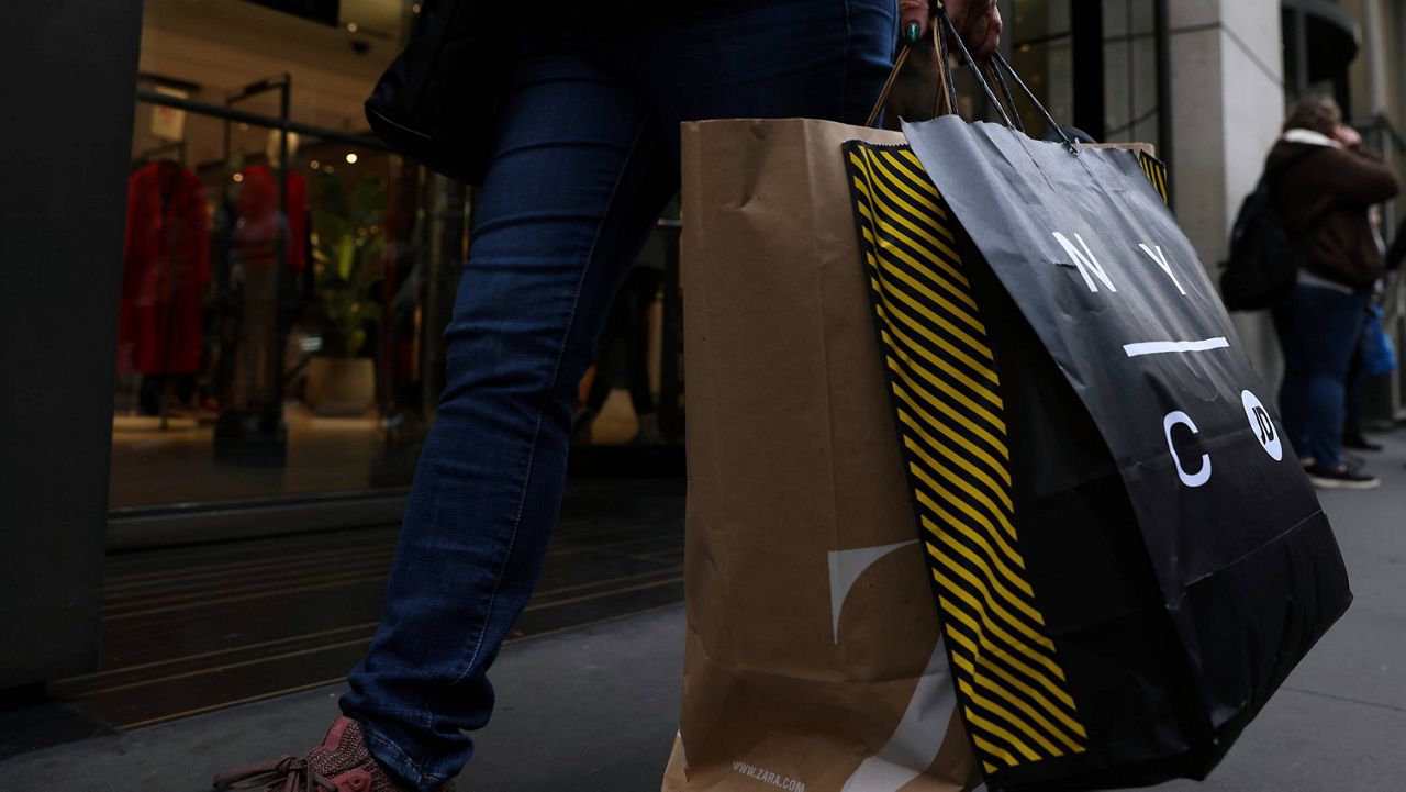 A shopper carries bags down Fifth Avenue on Friday, Nov. 25, 2022, in New York.  (AP Photo/Julia Nikhinson, File)