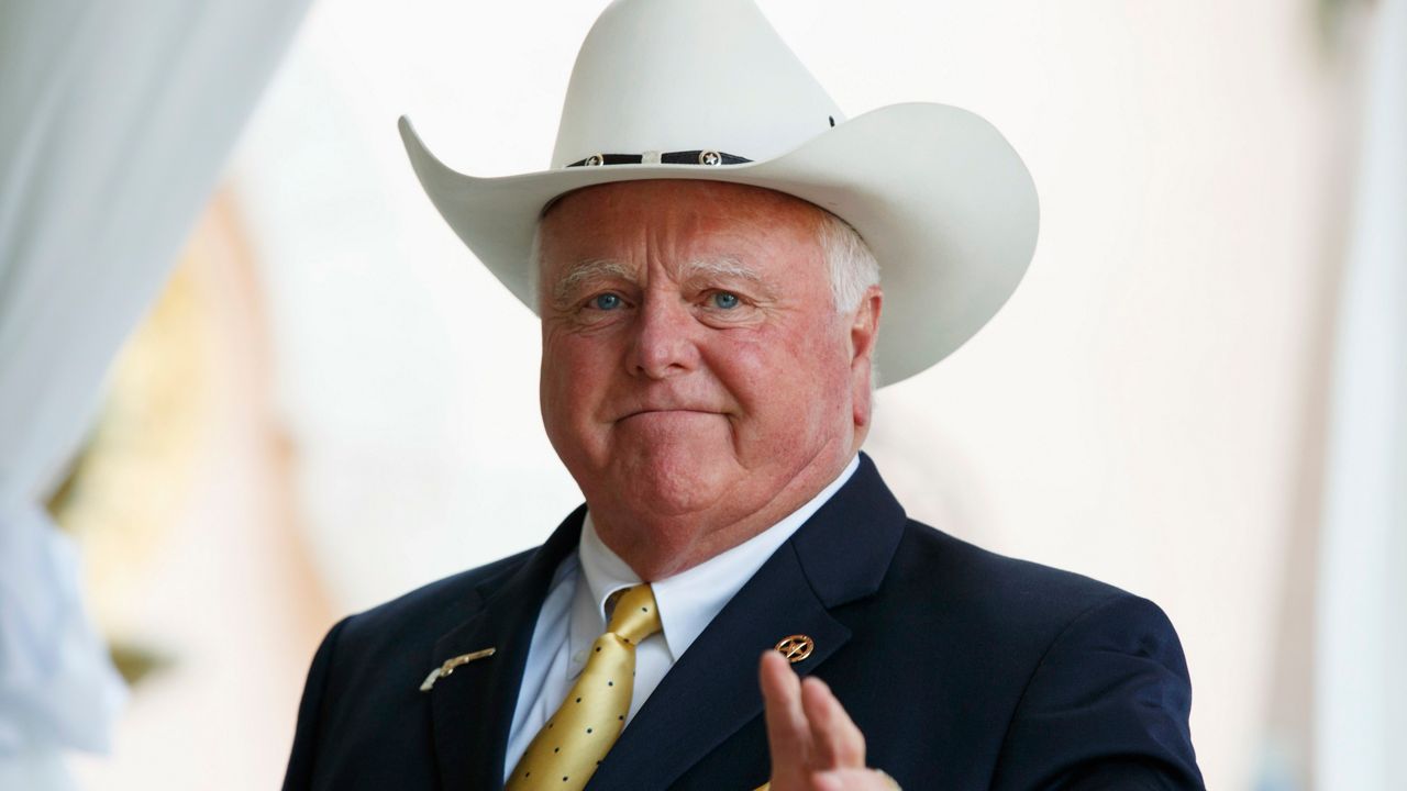 In this Dec. 30, 2016, file photo, Texas Agriculture Commissioner Sid Miller waves as he arrives at Mar-a-Lago to meet with President-elect Donald Trump's transition team in Palm Beach, Fla. Sid Miller who has been critical of measures Republican Gov. Greg Abbott has implemented to help slow down the coronavirus pandemic said Wednesday, Dec. 9, 2020 that he has tested positive for COVID-19. (AP Photo/Evan Vucci, File)