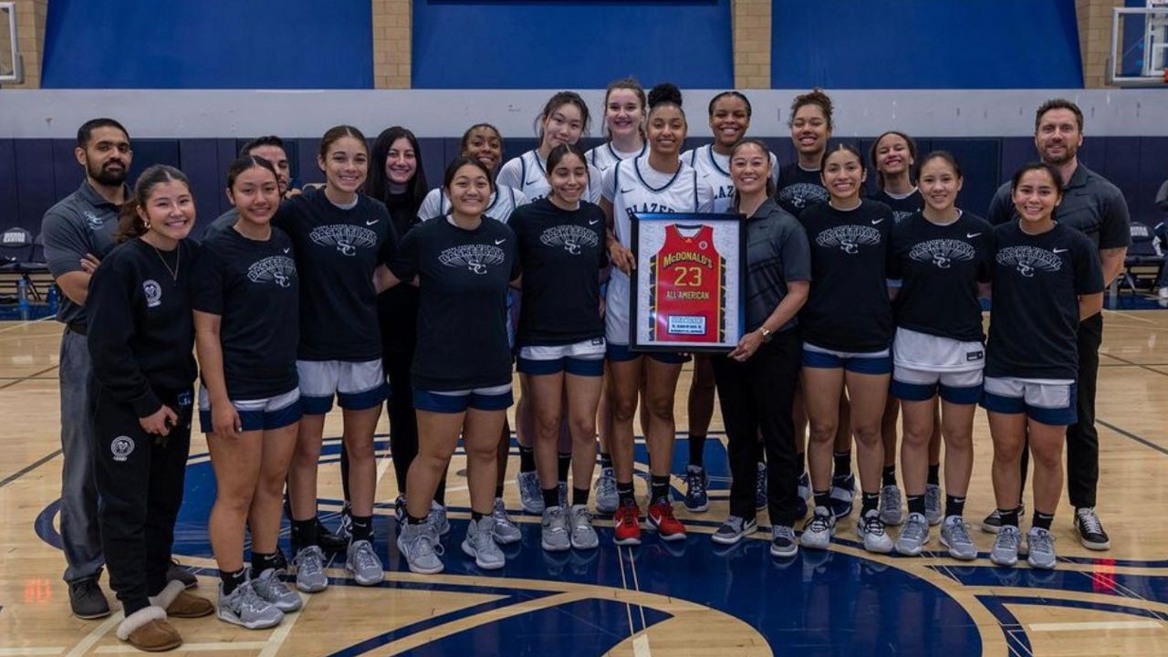 The Sierra Canyon girls basketball team stands alongside their teammate Juju Watkins. 