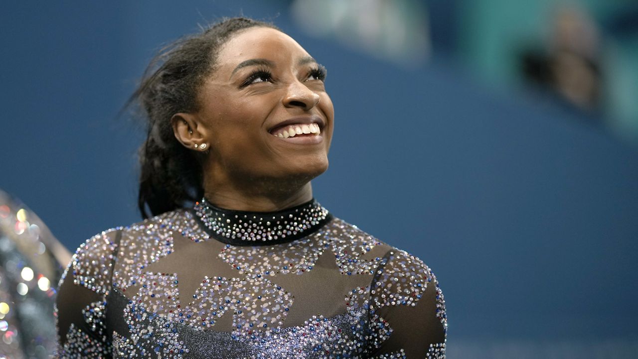 Simone Biles of the United States, smiles after competing on the uneven bars during a women's artistic gymnastics qualification round at Bercy Arena at the 2024 Summer Olympics, Sunday, July 28, 2024, in Paris, France. (AP Photo/Charlie Riedel)