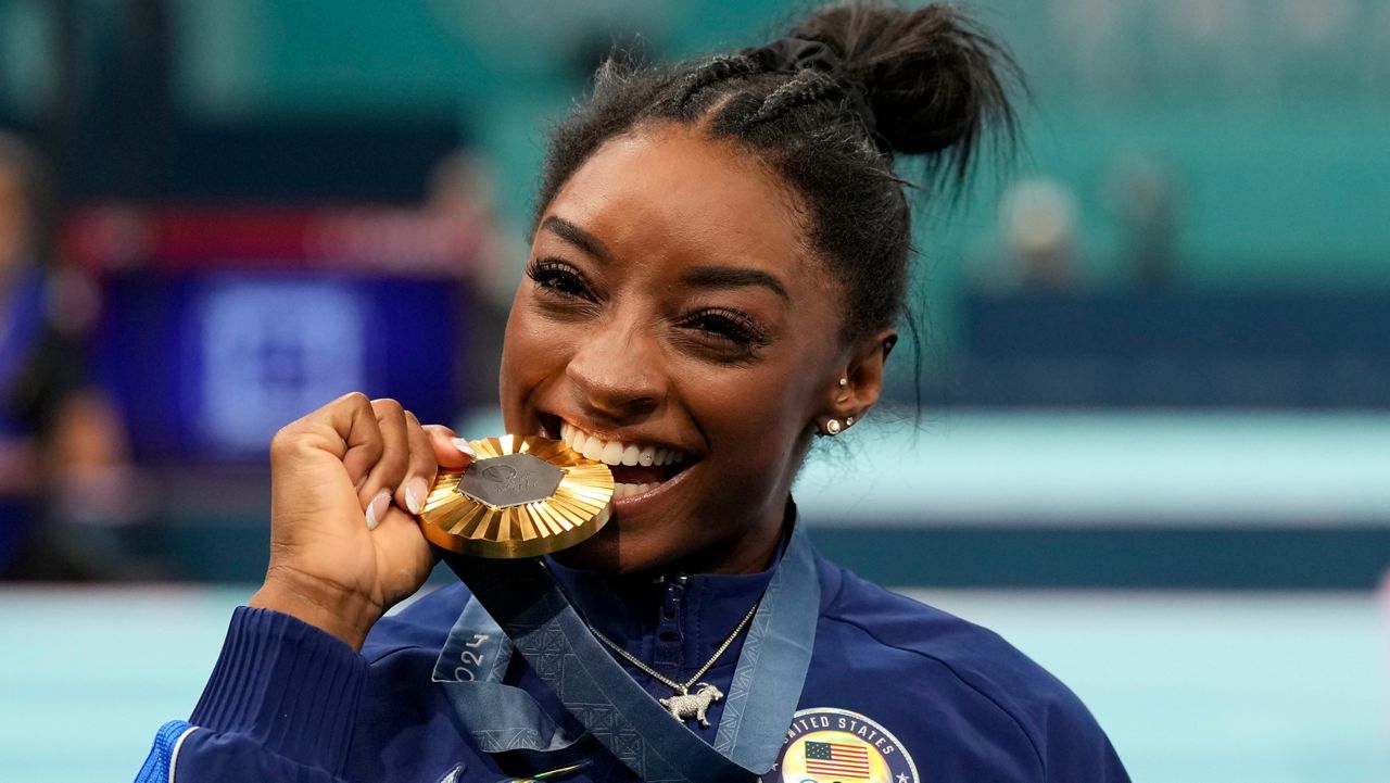 Simone Biles, of the United States, celebrates after winning the gold medal during the women's artistic gymnastics all-around finals in Bercy Arena at the 2024 Summer Olympics, Thursday, Aug. 1, 2024, in Paris, France. (AP Photo/Abbie Parr)